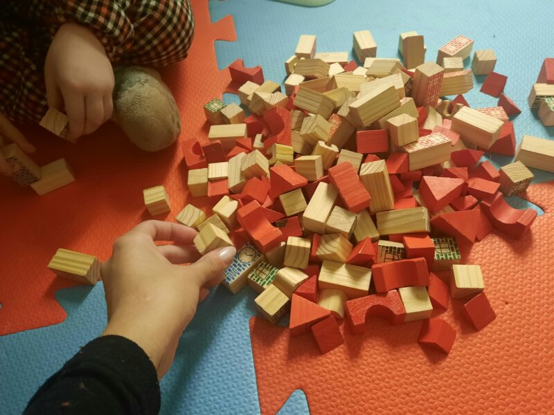 Kinder spielen mit Holzbausteinen